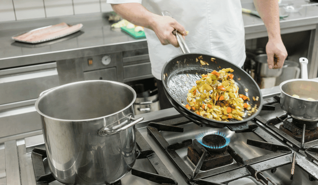 Cook preparing vegetables in a commercial restaurant kitchen, illustrating how on-demand hiring apps help restaurants cover staffing needs