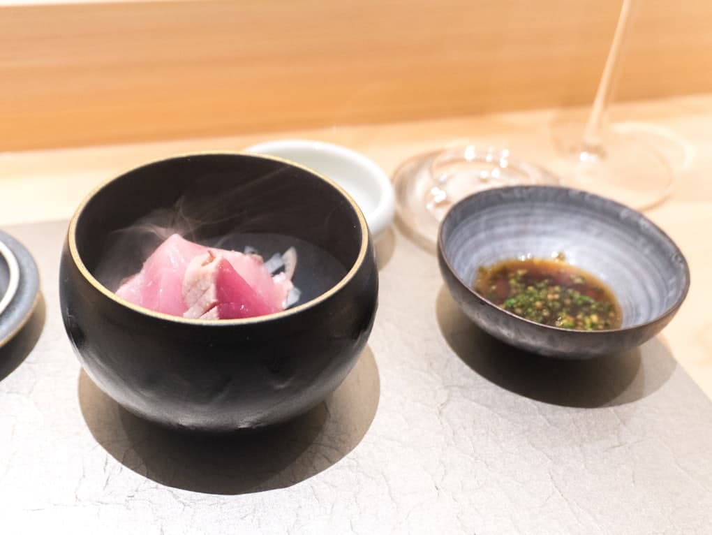 Two bowls of a chef’s tasting course on a counter