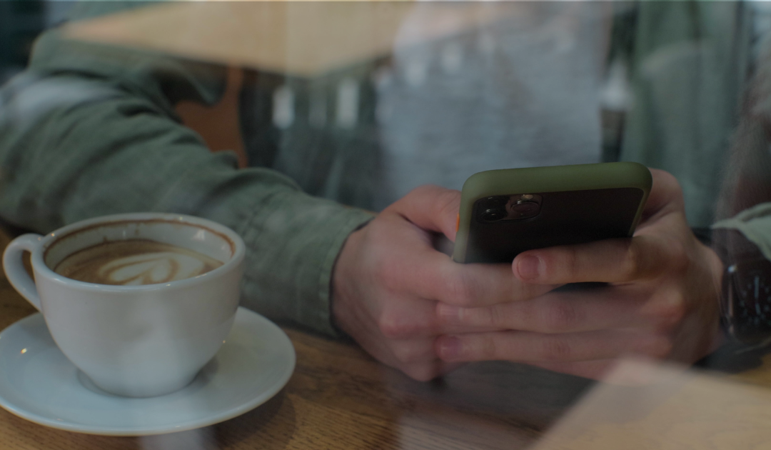 Candidate checking their phone while keeping candidates warm during the hiring process